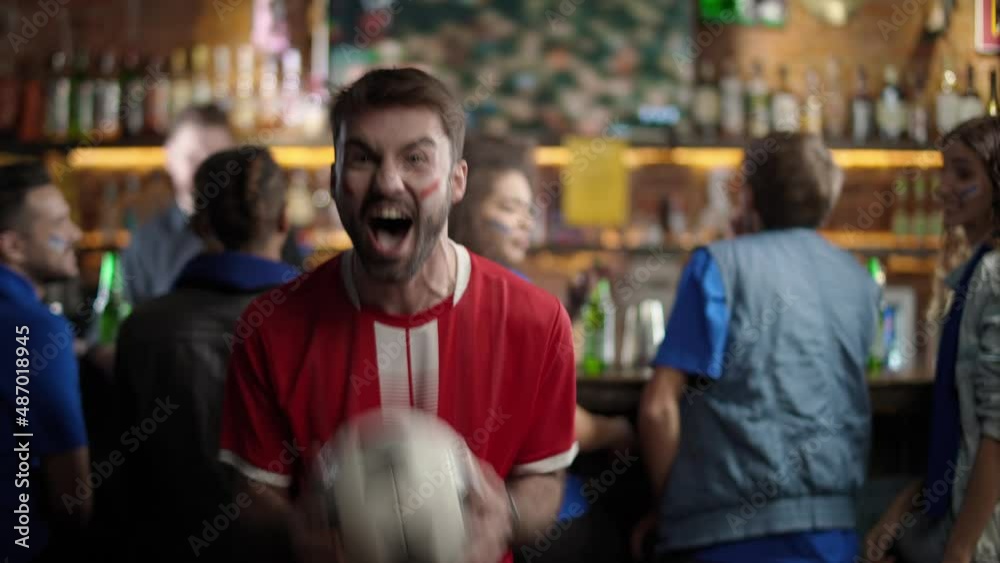 Football fans drink beer and watching a football match at the bar, fan of the opposite team enjoy scoring a goal during a football match and rejoices at the victory. Football fans drink beer and watching a football match at the bar, fan of the opposite team enjoy scoring a goal during a football match and rejoices at the victory.