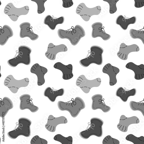 Seamless pattern featuring warm knitted socks and in black and white colors. Vector repeat texture.