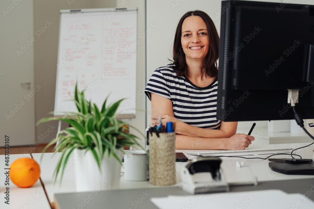 Confident woman sitting at her desk in a modern office
