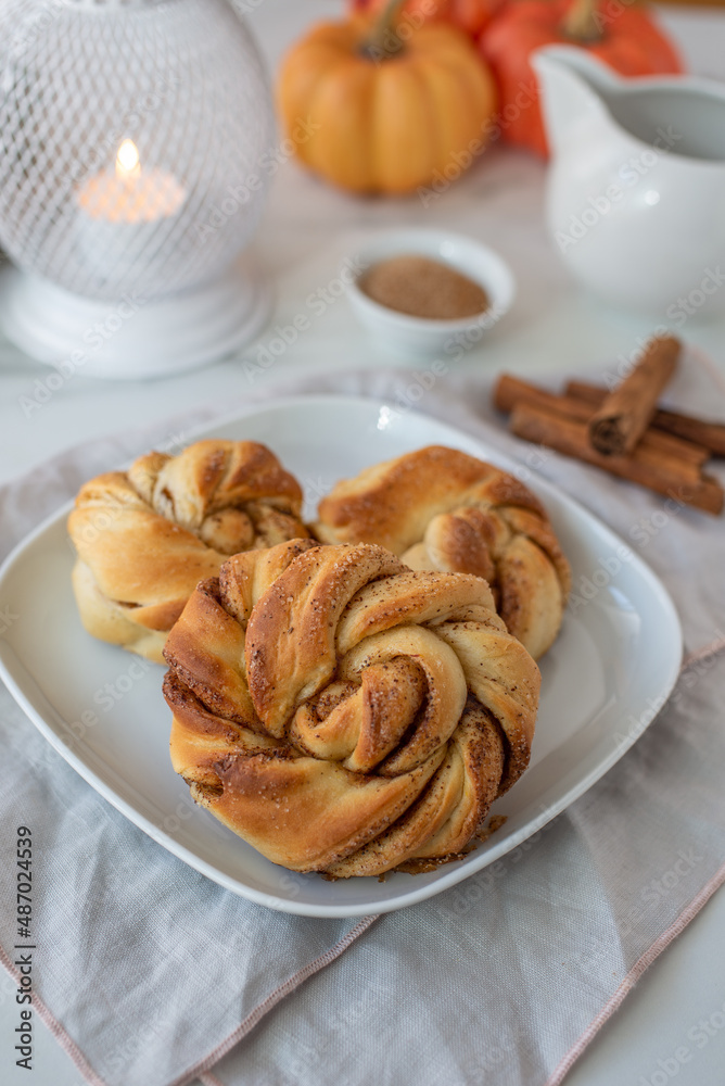 Sweet home made pumpkin cinnamon rolls on a table Sweet home made pumpkin cinnamon rolls on a table