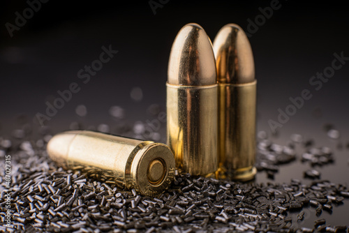 Macro shot of pistol cartridges in a pile of gunpowder, limited depth of field, soft focus