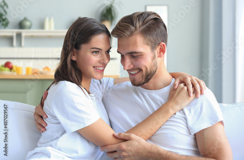 Happy young couple hugging and looking at each other at home interior.