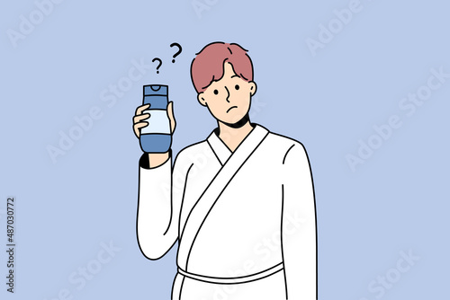 Cosmetics and treatments for men concept. Young man wearing bathtub standing cosmetic bottle in hands with question mark nearby vector illustration 