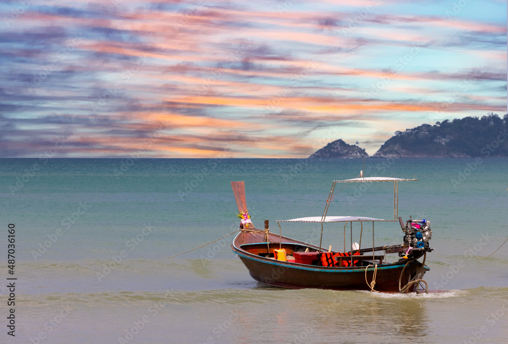 Long tail Boat on colourful sunset over a Beach in Phuket Thailand