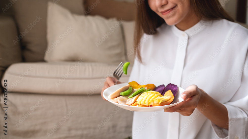 Closeup image of a young woman eating vegetables, Vegan, Clean food, dieting concept Closeup image of a young woman eating vegetables, Vegan, Clean food, dieting concept