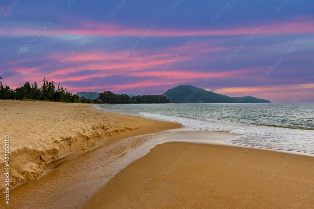 colourful sunset over Maikhao Beach Phuket Thailand. Magnificent colours in the sky and turquoise blue waters and white sandy beach 