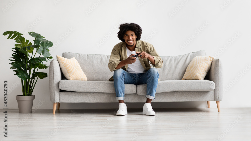 Domestic Leisure. Cheerful Black Millennial Guy Playing Video Games At Home Domestic Leisure. Cheerful Black Millennial Guy Playing Video Games At Home