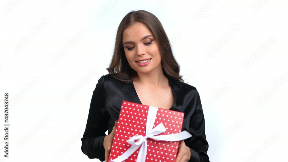 Fashion brunette woman dancing flirting smiling with red gift box blowing air kiss posing isolated Fashion brunette woman dancing flirting smiling with red gift box blowing air kiss posing isolated