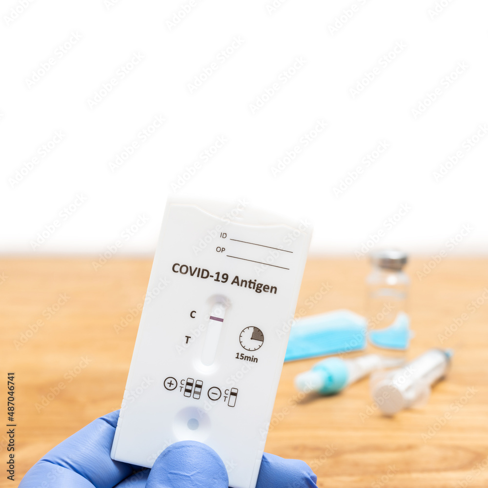 Hand in a medical glove holds rapid antigen test kit for viral disease COVID-19 with negative result, copy space Hand in a medical glove holds rapid antigen test kit for viral disease COVID-19 with negative result, copy space