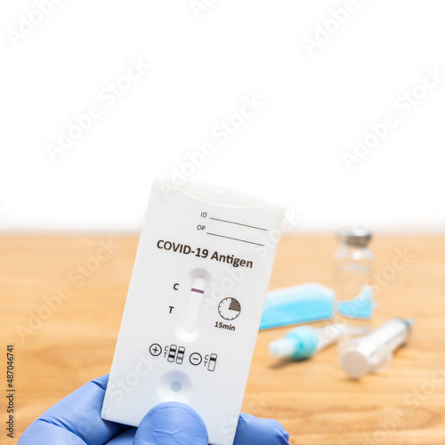 Hand in a medical glove holds rapid antigen test kit for viral disease COVID-19 with negative result, copy space