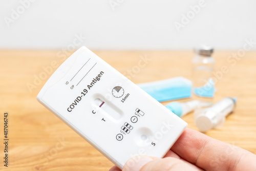 Hand holds rapid antigen test kit for viral disease COVID-19 with negative result, copy space