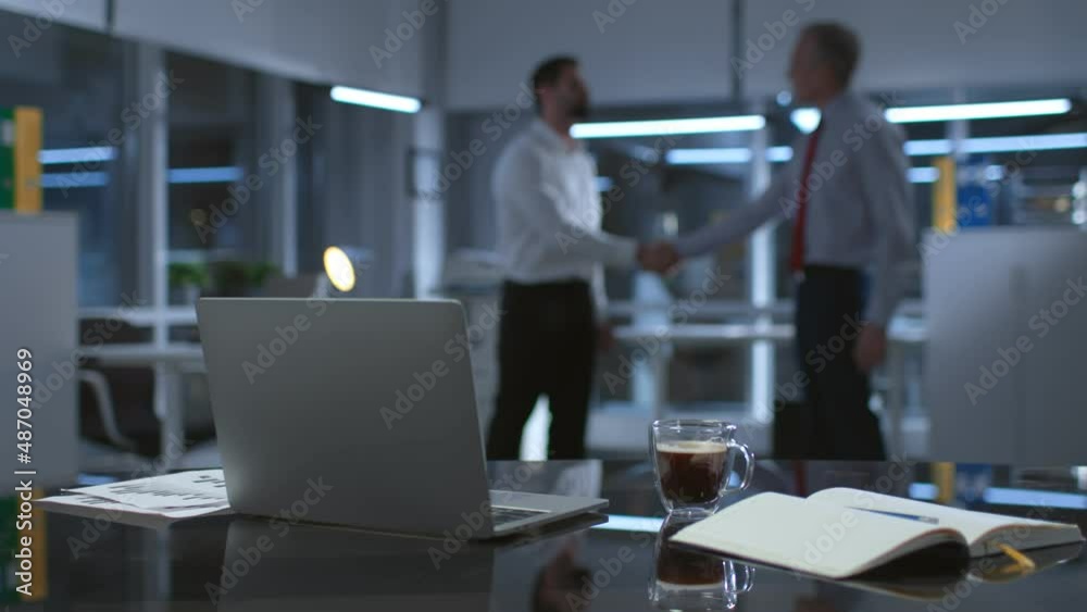 Blur shot of business partner shaking hands late in office Blur shot of business partner shaking hands late in office