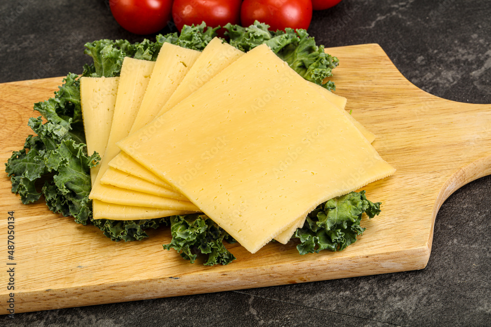 Sliced Gauda cheese over board Sliced Gauda cheese over board