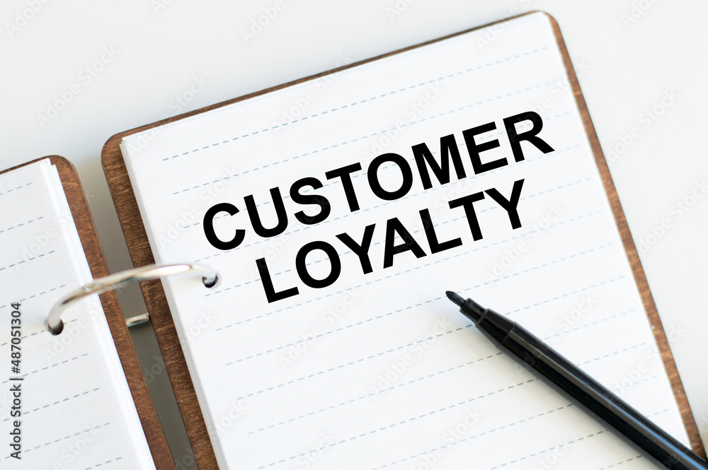 customer loyalty on notepad on white table, business concept customer loyalty on notepad on white table, business concept