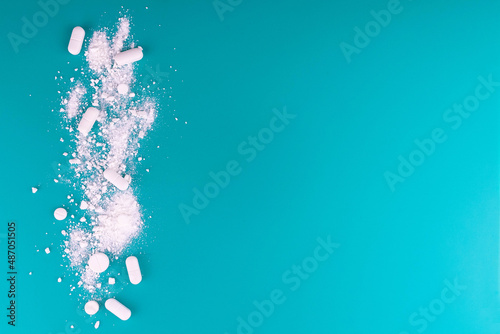 Medical background.Crushed pills on a blue background.Copy space.