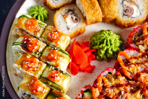 Close up top view of sushi set rolls with cucumber, shrimp tempura. selective focus