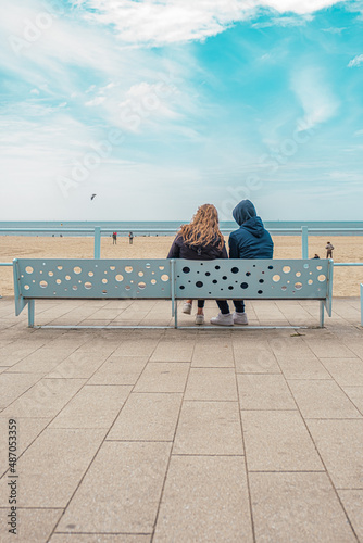 Quadro em tela a couple is sitting together on a bench with a sea view on the boulevard in Sche