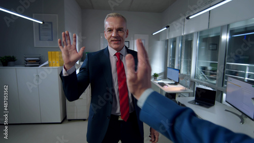 Pov shot of businessman giving high five to colleague in office photo