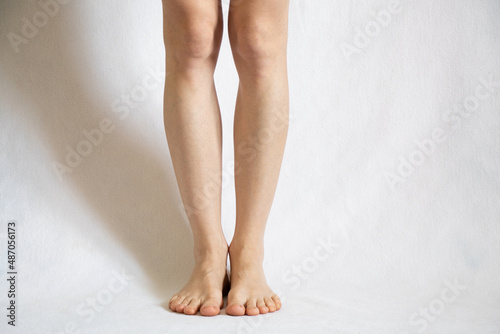 female bare legs on a white background close up,feet on white