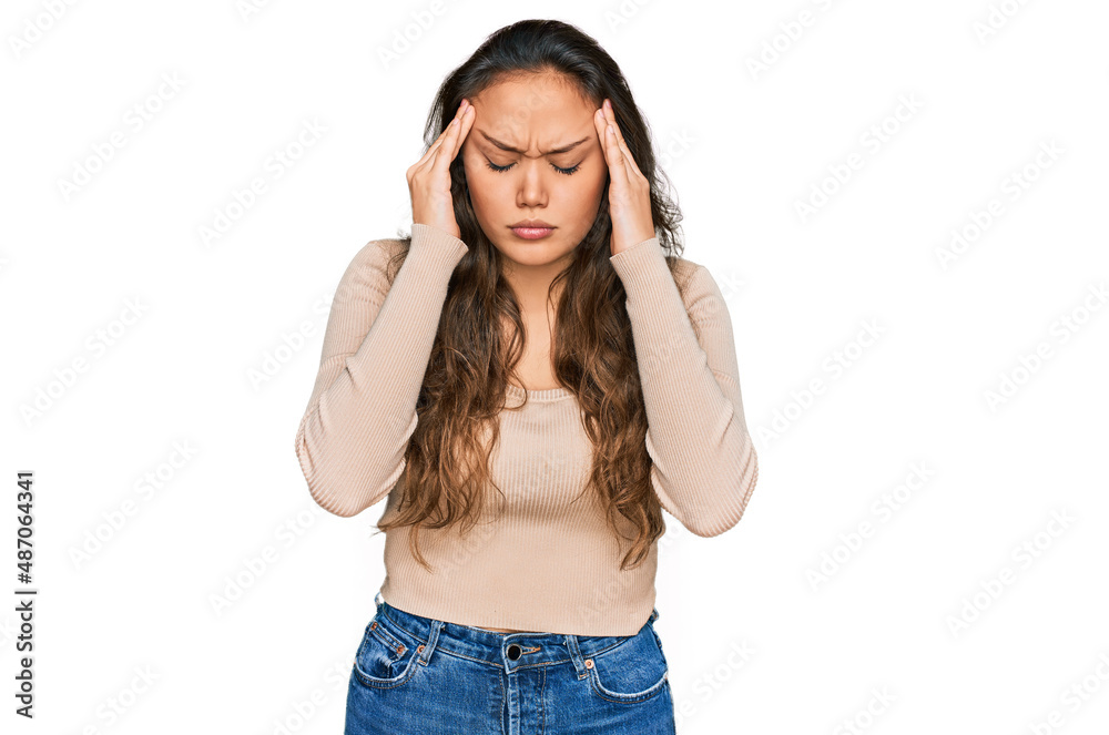 Young hispanic girl wearing casual clothes with hand on head for pain in head because stress. suffering migraine. Young hispanic girl wearing casual clothes with hand on head for pain in head because stress. suffering migraine.