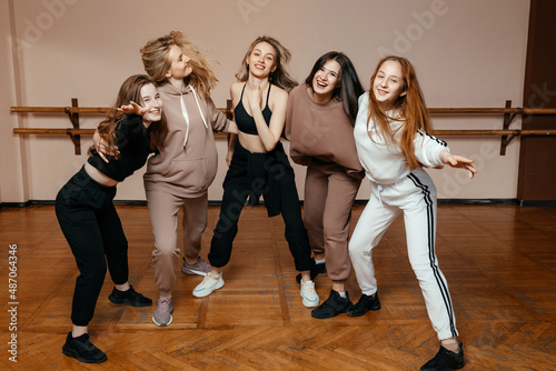 Group of girls in sportswear, performing elements of house dance in a dance studio, dancing with pleasure. concept of sports youth