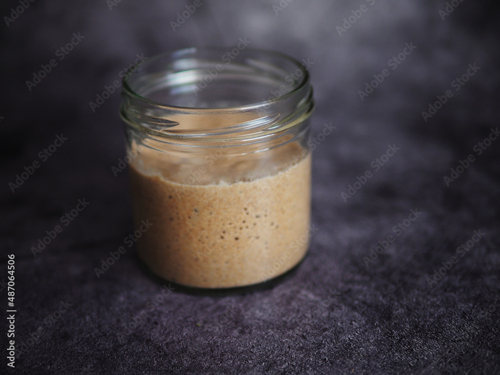 Homemade bread sourdough in a glass jar on a dark background. Homemade bread sourdough in a glass jar on a dark background.