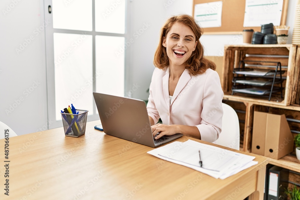 Young caucasian businesswoman smiling happy using laptop working at the office. Young caucasian businesswoman smiling happy using laptop working at the office.