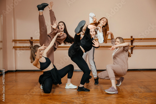 Group of girls in sportswear, performing elements of house dance in a dance studio, dancing with pleasure. The concept of sports youth