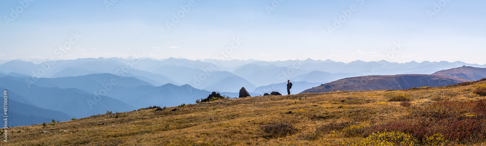 Mountain landscape with a panoramic view and the figure of a man looking into the distance.