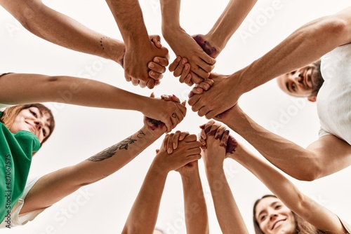 Group of young friends with hands together.