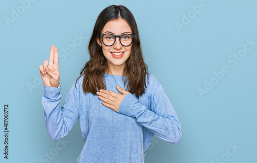 Εκτύπωση καμβά Young beautiful woman wearing casual clothes and glasses smiling swearing with h