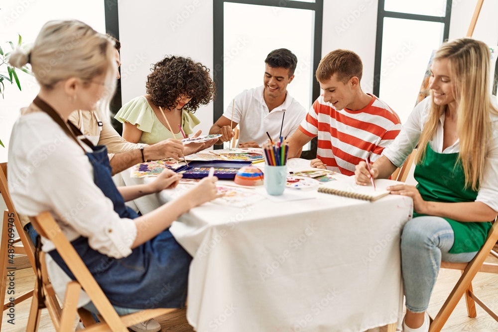 Group of people smiling happy drawing sitting on the table at art studio. Group of people smiling happy drawing sitting on the table at art studio.