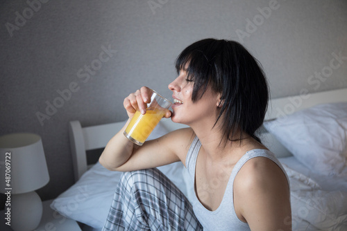 Good looking woman holding a glass of orange juice. Good morning. Happy day