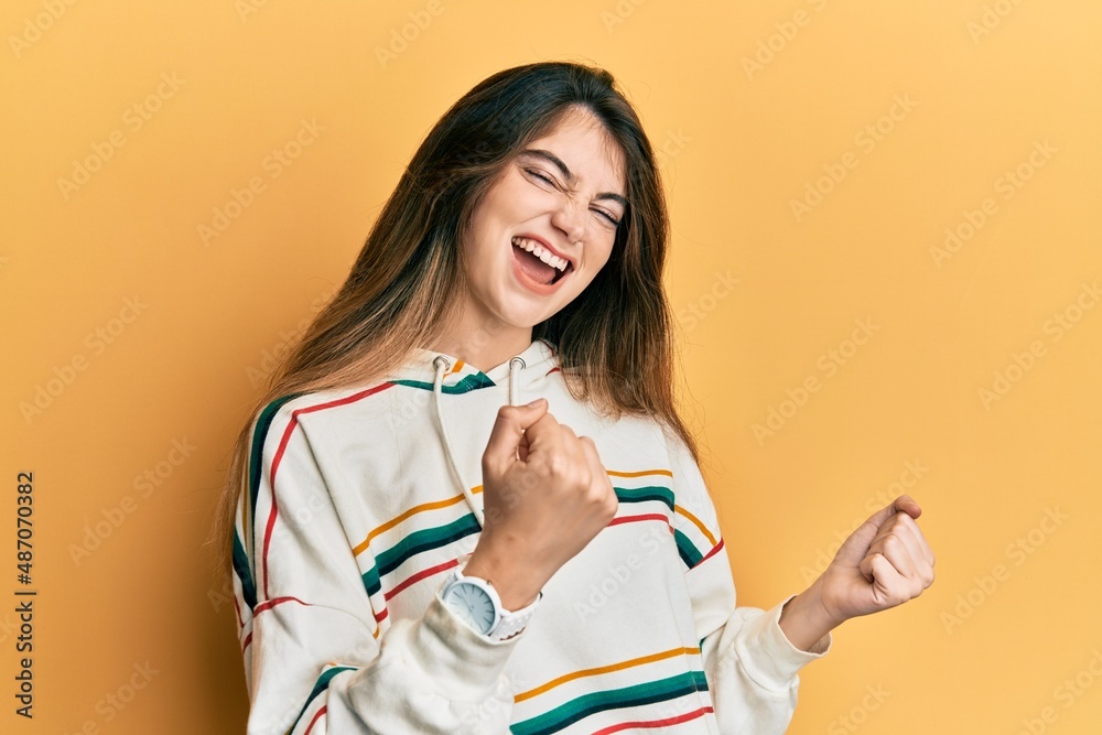 Young caucasian woman wearing casual clothes celebrating surprised and amazed for success with arms raised and eyes closed. winner concept. Young caucasian woman wearing casual clothes celebrating surprised and amazed for success with arms raised and eyes closed. winner concept.