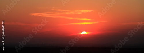 Beautiful red sky background at sunset with sun and cloud line