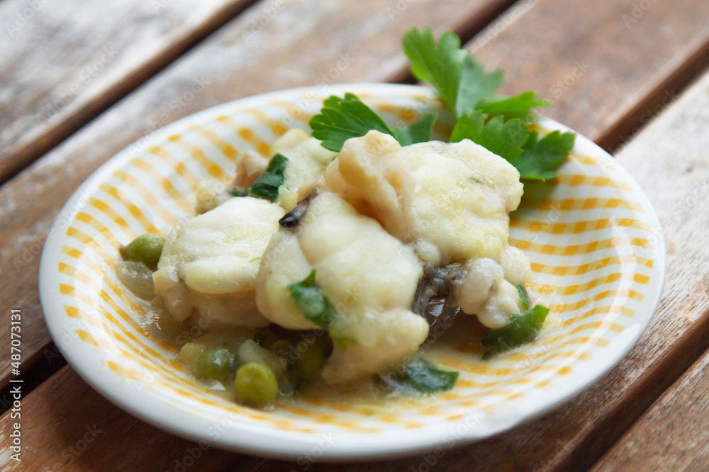 fish dish in sauce with peas and parsley fish dish in sauce with peas and parsley