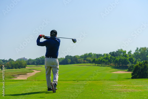 Man Golfer Hitting Ball with Club on Beatuiful Golf Course