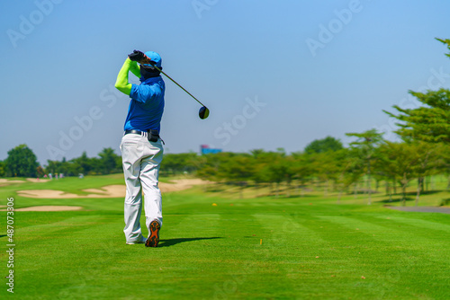 Man Golfer Hitting Ball with Club on Beatuiful Golf Course