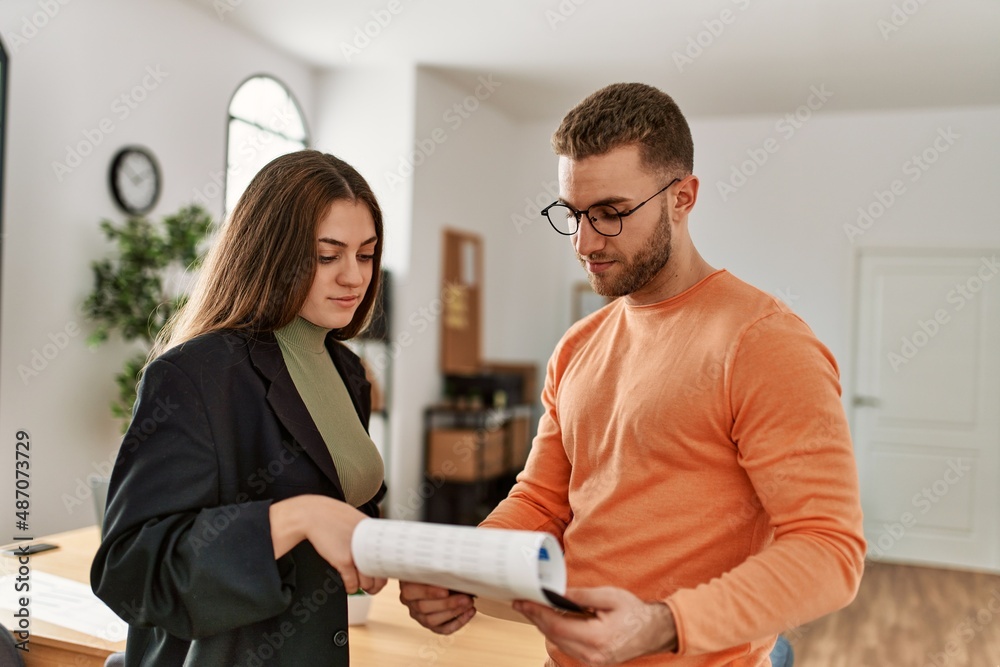 Fototapeta premium Two caucasian business executives working at the office.