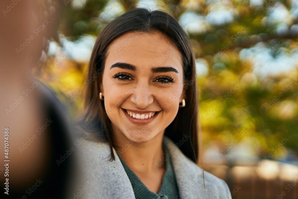 Young hispanic girl smiling happy making selfie by the camera at the city. Young hispanic girl smiling happy making selfie by the camera at the city.