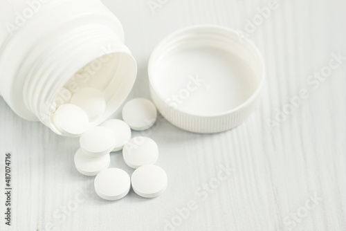 Foto pills, a glass thermometer, a mask on a light table