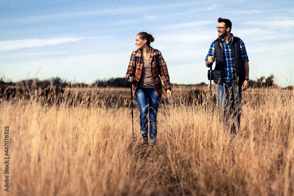 Couple with backpacks hiking together in nature on autumn day. Couple with backpacks hiking together in nature on autumn day.