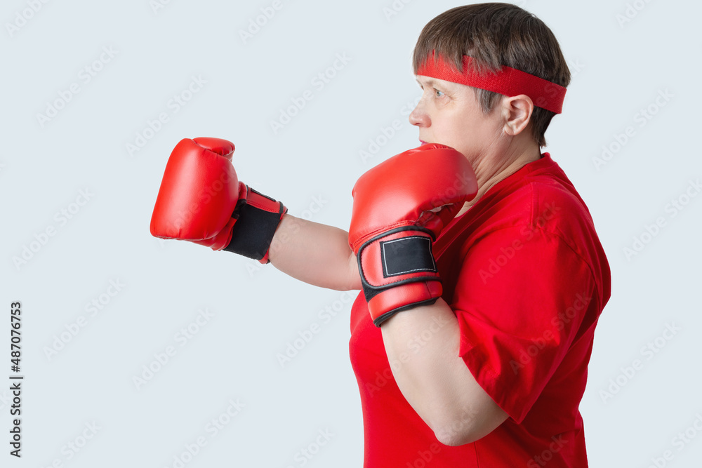 Elderly woman boxer in red on a white background.