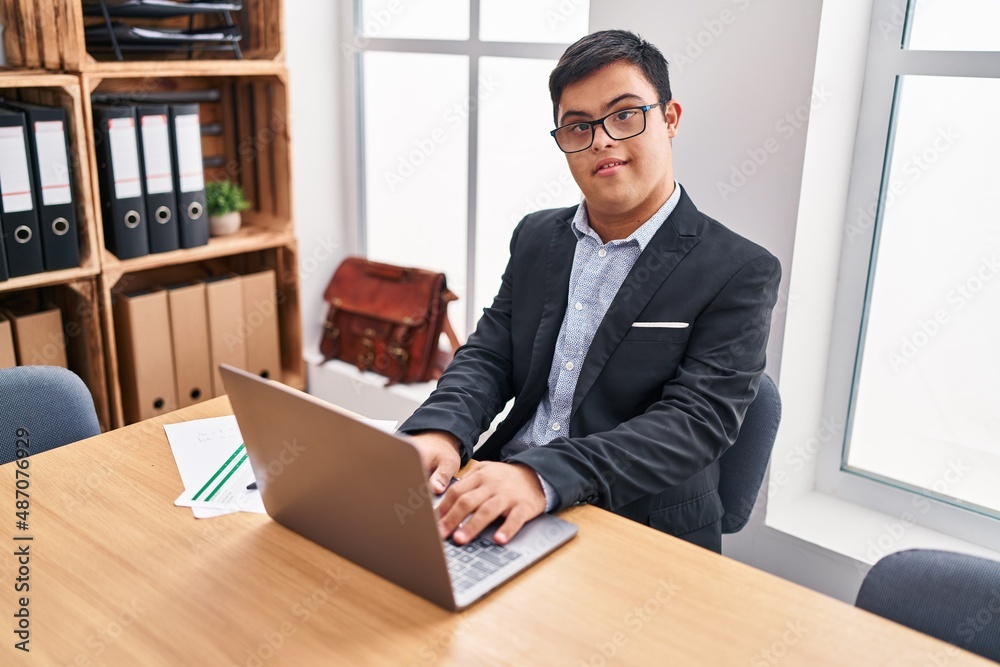 Down syndrome man business worker using laptop working at office Down syndrome man business worker using laptop working at office