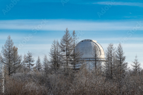 Telescope tower of the Sayan Astrophysical Observatory among the winter forest