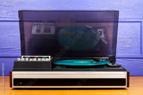 Vintage turntable vinyl record player with turquoise vinyl