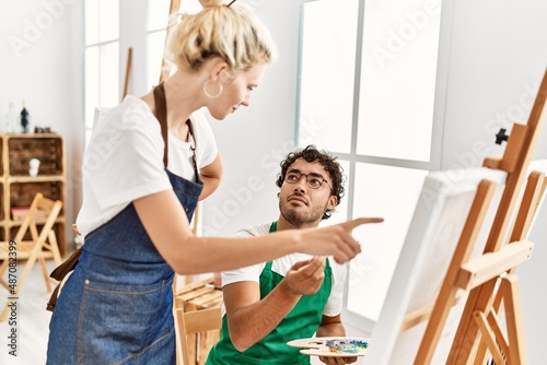 Paint teacher woman teaching to student man at art studio.