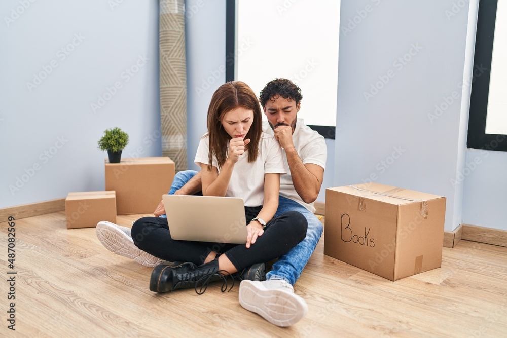 Young couple using laptop at new home feeling unwell and coughing as symptom for cold or bronchitis. health care concept. Young couple using laptop at new home feeling unwell and coughing as symptom for cold or bronchitis. health care concept.