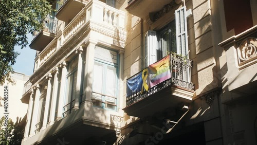Flags LGBT and EU on balconies in Europe. Gay pride banner flag rainbow mounted to building.