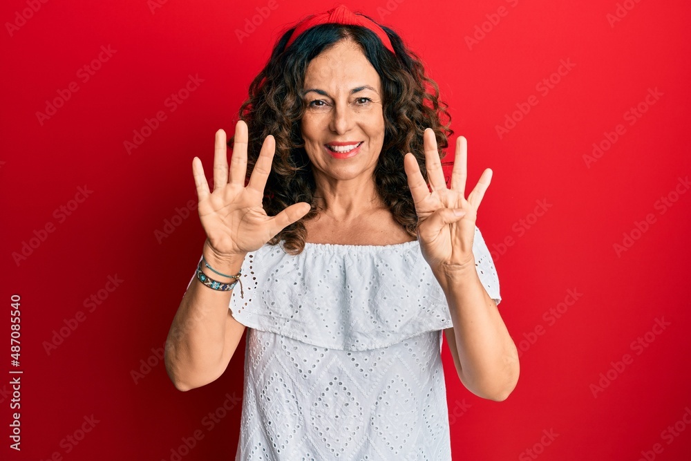 Middle age hispanic woman wearing casual clothes showing and pointing up with fingers number nine while smiling confident and happy. Middle age hispanic woman wearing casual clothes showing and pointing up with fingers number nine while smiling confident and happy.